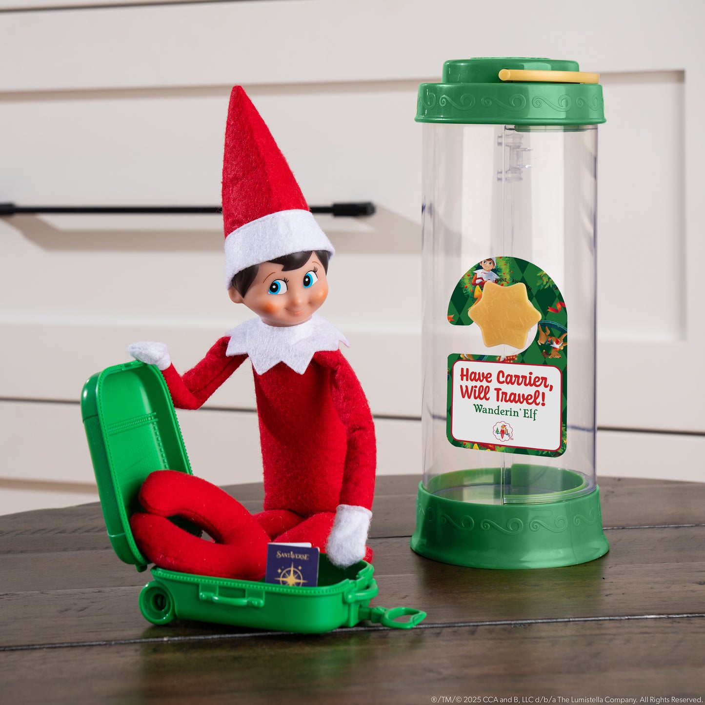 A Scout Elf packs his suitcase in preparation to go on a trip in his Scout Elf® Carrier, Ltd. 20th Anniversary Ed. Kit.