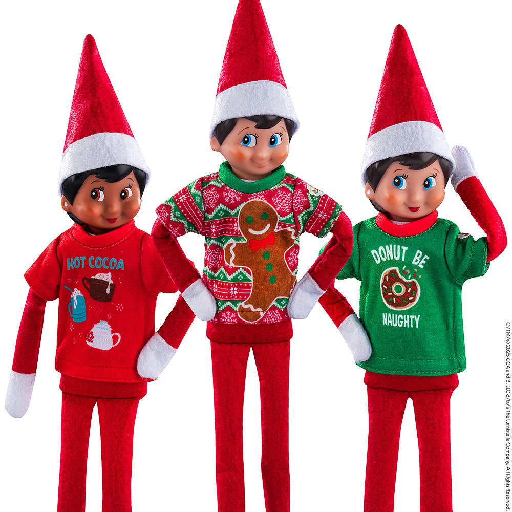 A trio of Scout Elves, each donning a t-shirt from the Claus Couture Collection® Festive Fun T-Shirt Set.