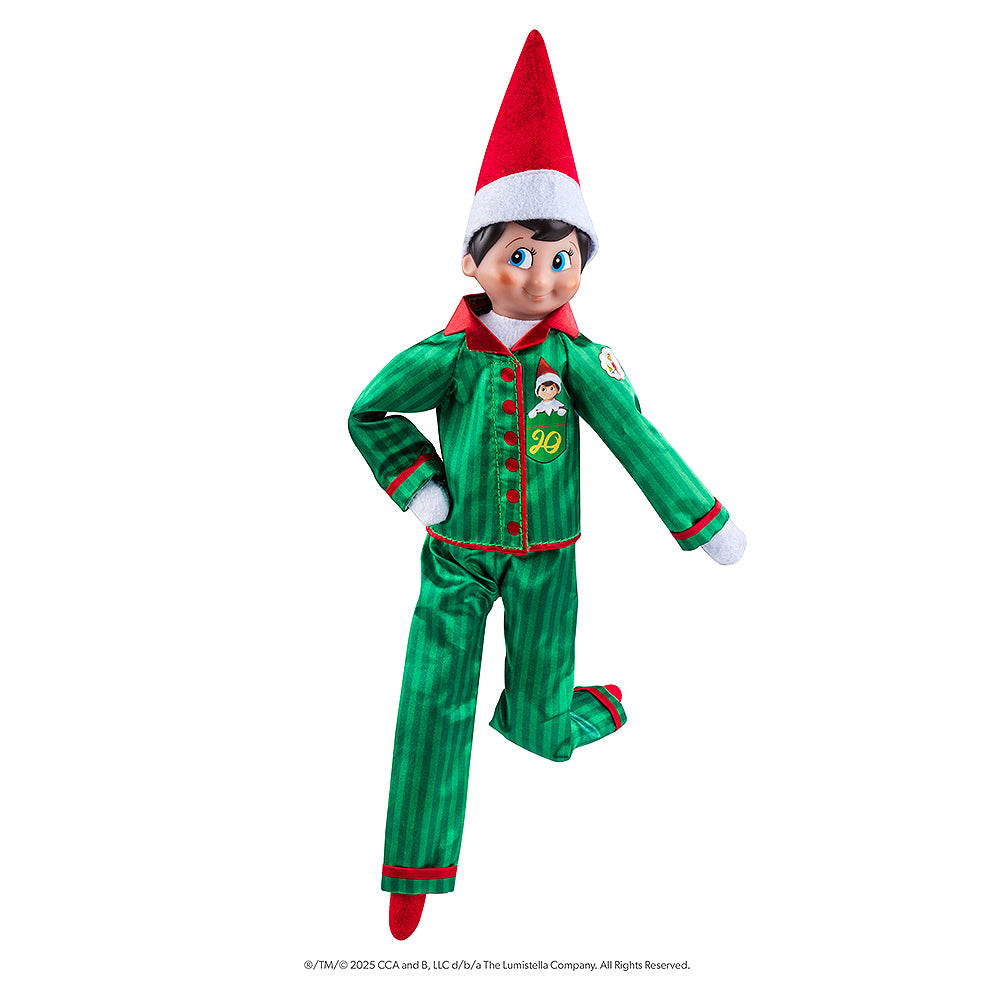 The adoptable boy limited-edition 20th anniversary Scout Elf® with blue eyes and flexible bending limbs for even easier elf scenes, donning the limited-edition luxury satin long pajama set.