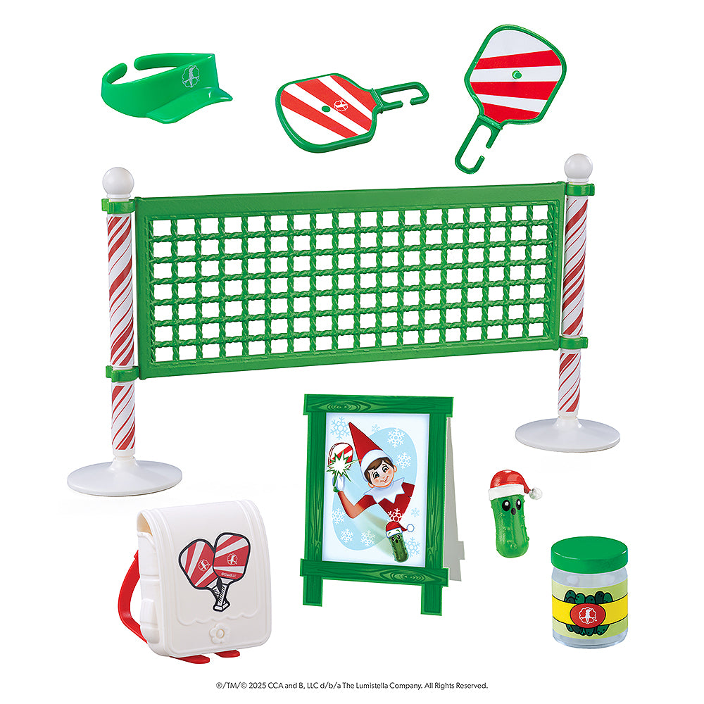 An image showcasing the individual pieces of the Polar Props™ Pickleball Play Pack, which include the following: Pickleball net and paddle, Pickleball sign, Elf-size visor and pack, Jar and pickle.