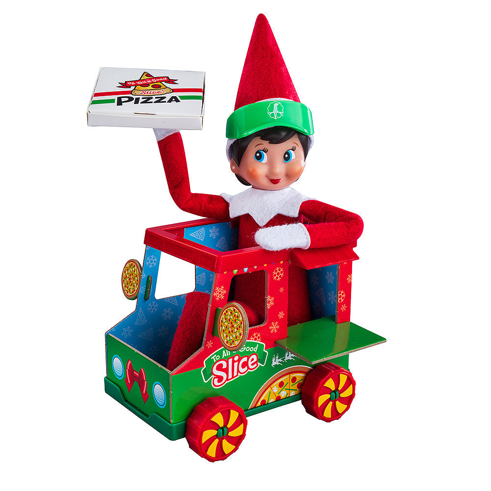 A girl Scout Elf posing with the Polar Props™ Polar Pizza Truck. She is holding the pizza box into the air while driving the truck to make a special delivery!