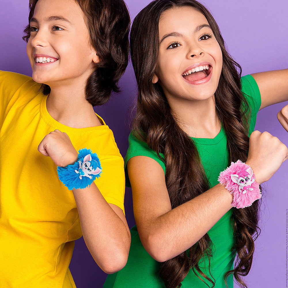 A pair of children wearing bright colors pose with the Bogie™ Wrap-Alongs (the blue and pink options) on their wrists in front of a purple background.