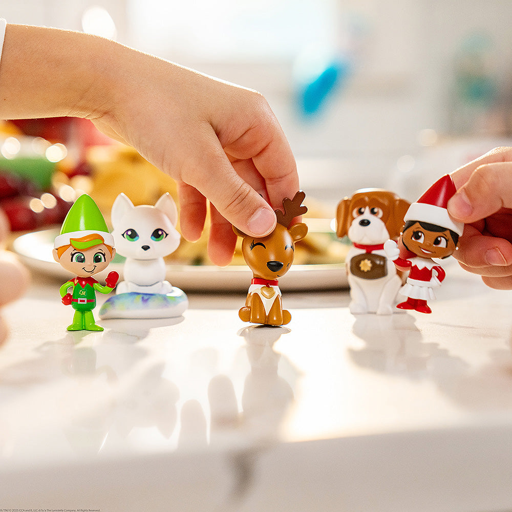 An up close shot of a child's hand playing with the Santaverse™ Minis (Series 5).