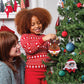 A mother and her daughter hang the Santaverse™ Celebration Ornament reindeer plush on their Christmas tree
