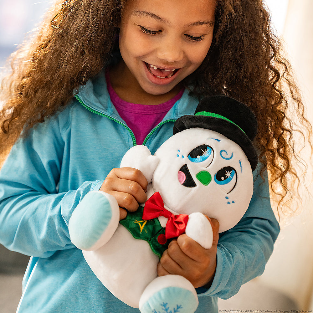 A little girl snuggles SnoStax™ Razzle the Celebration Snowman plush