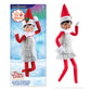 The Claus Couture Collection® Tiny Tinsel Dress packaging (left-hand side) next to a Scout Elf modeling the dress (right-hand side).