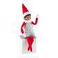 A girl Scout Elf® sits while modeling the Claus Couture Collection® Tiny Tinsel Dress while waving.