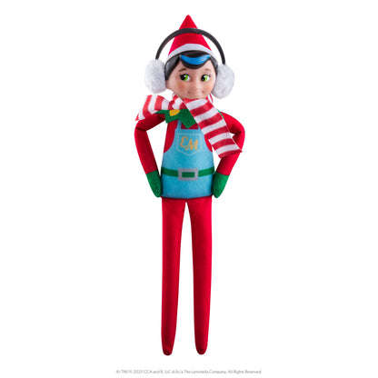 The Elf Mates® Chef with brown hair, posed standing with his hands on his hips. He is wearing a set of earmuffs and a scarf.
