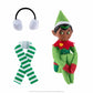 The Elf Mates® Cobbler with black hair, posed sitting holding his knees to his chest. To the left of the elf is a set of earmuffs and a scarf.