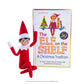 The adoptable boy limited-edition 20th anniversary Scout Elf® with blue eyes and flexible bending limbs for even easier elf scenes, pictured alongside the artfully illustrated 20th anniversary edition storybook.