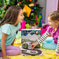 A pair of girls playing with the Spin & Soar 12-Day Countdown to Christmas advent calendar set toys in front of the Christmas tree