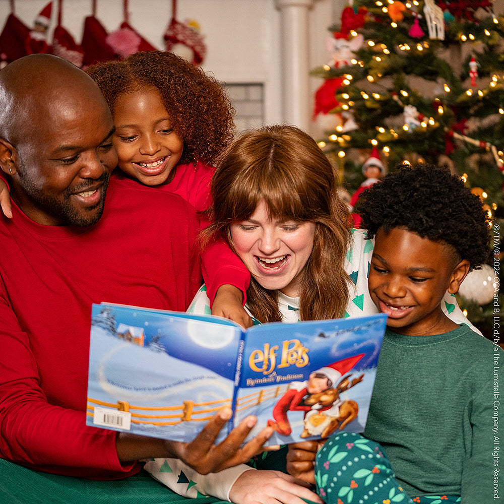 A family reads Elf Pets: A Reindeer Tradition around the Christmas tree