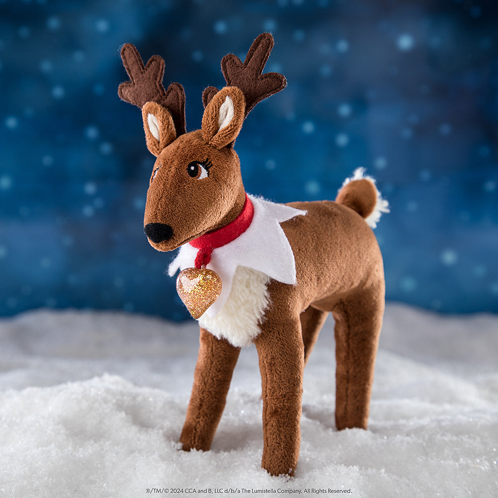 Elf Pets Reindeer standing in snow with a night sky and snowflakes falling in the background