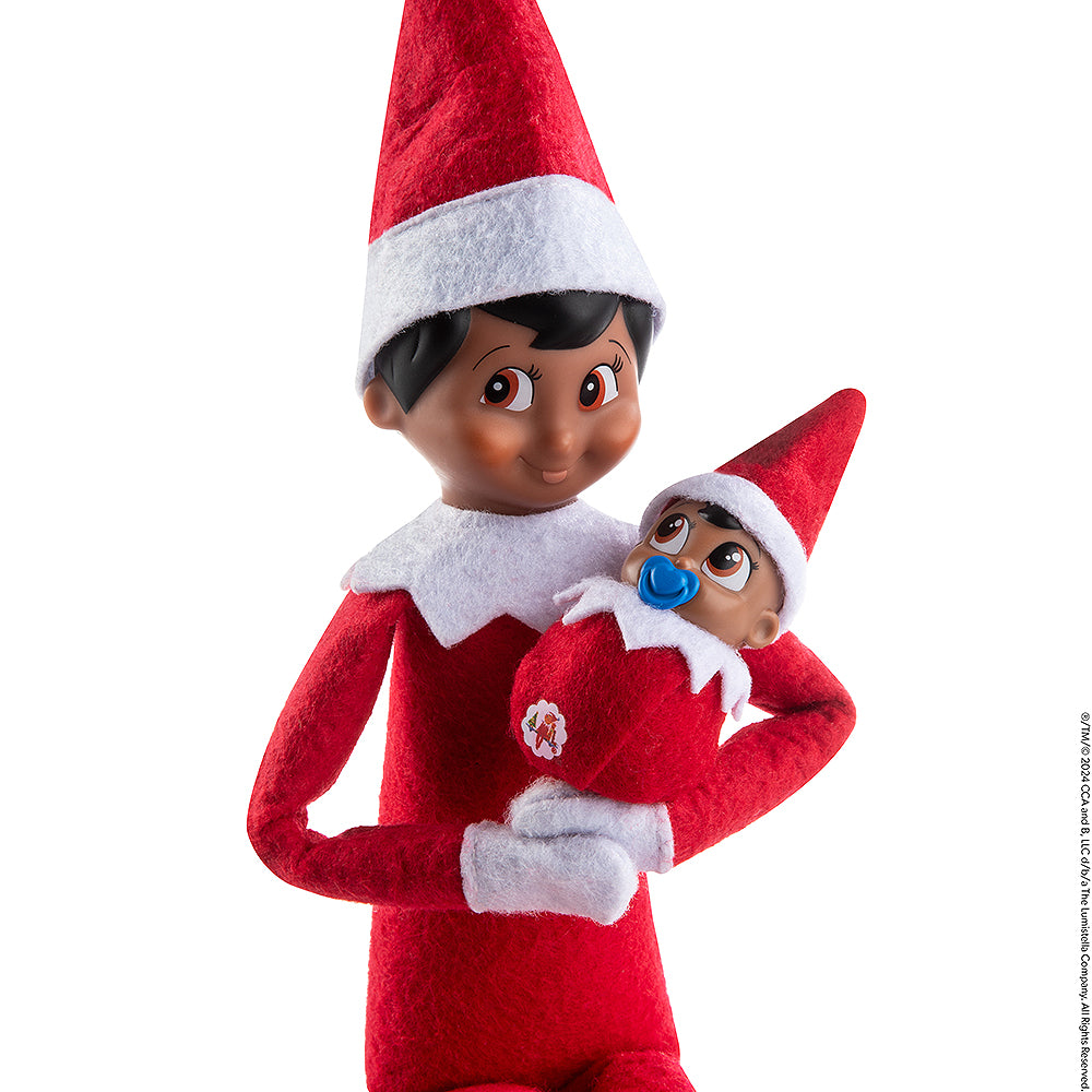 Scout Elf® cradling Frost Pips™ boy in her arms