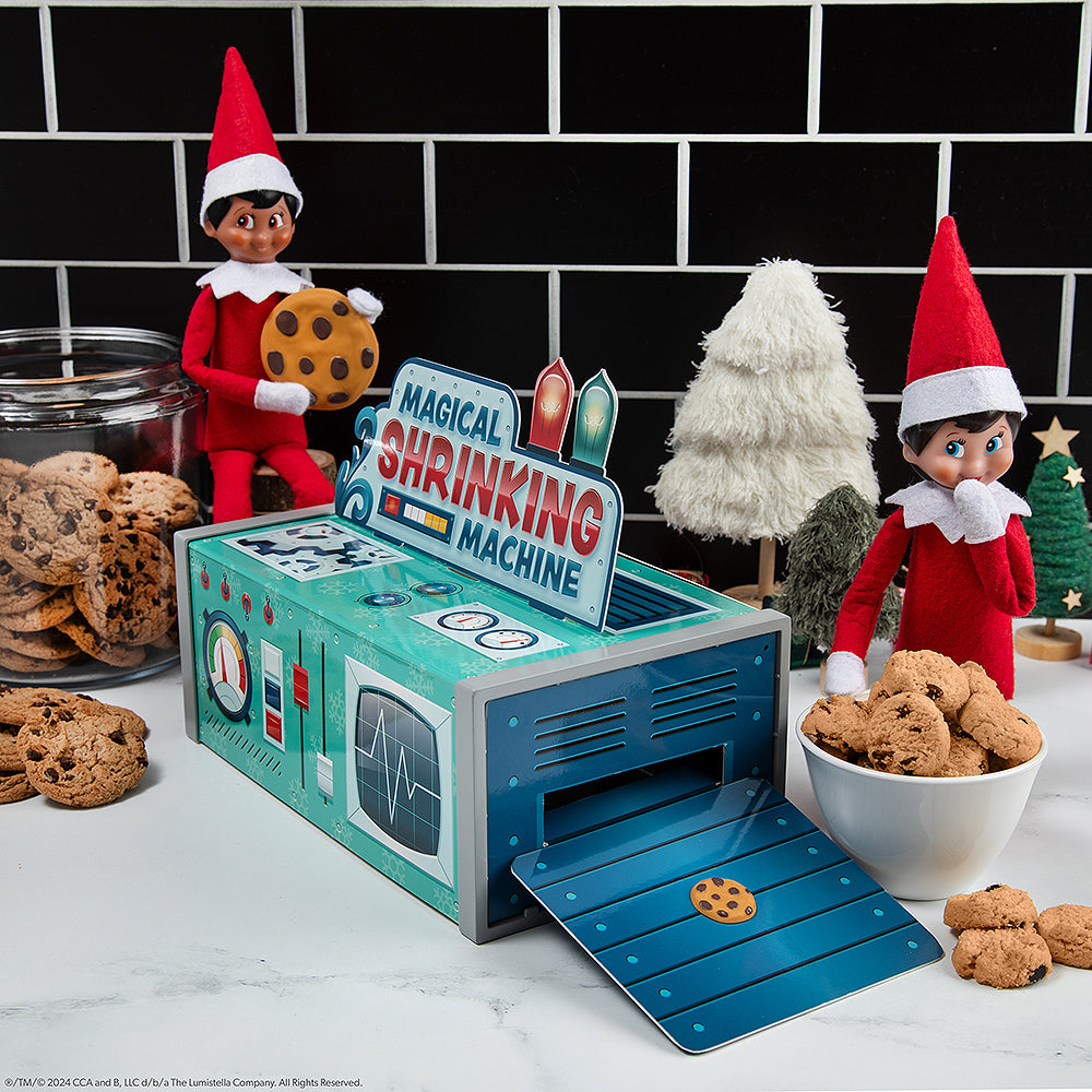 A pair of Scout Elves using the Polar Props Shrinking Machine to shrink chocolate chip cookies