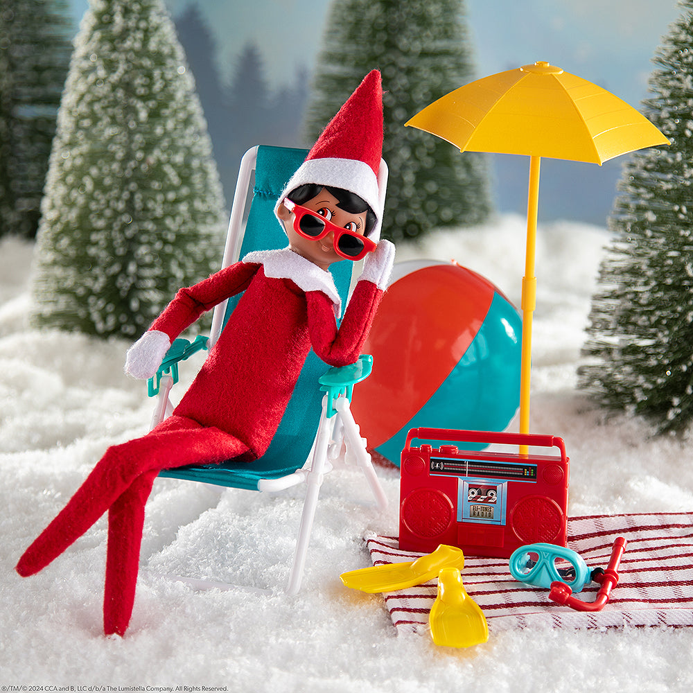 Scout Elf staged relaxing with the Polar Props beach set in a wintery wonderland