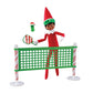 A girl Scout Elf playing pickleball with the Polar Props™ Pickleball Play Pack. She is taking a swing at the festive pickle at the net.