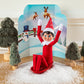 A Scout Elf® staged with the Polar Props™ 24-Day Ultimate Elf Ideas Kit items from Day 12, which is a tiny sled and a snowy, winter wonderland backdrop