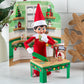 A girl Scout Elf® staged with the Polar Props™ 24-Day Ultimate Elf Ideas Kit items from Day 23, which is a kitchen backdrop and a kitchen table with a recipe book, Christmas cookies and a rolling pin