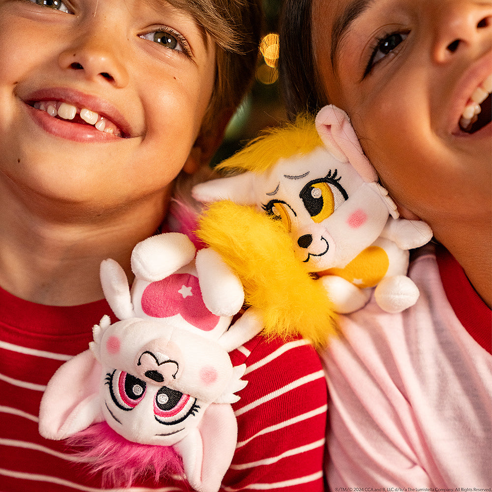 A boy and girl posing with the yellow and red Bogie™ Plush