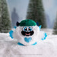 SnoBiggie™ Yeti SnoBall Surprise plush with beanie in a snowy forest