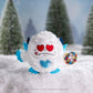 SnoBiggie™ Yeti SnoBall Surprise plush with donut and heart eyes in a snowy forest