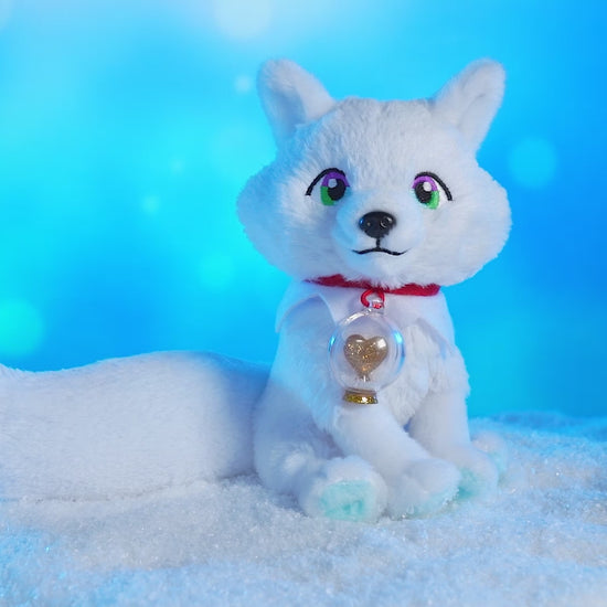 Product video of the Arctic Fox plush on a turntable spinning around in an arctic-themed environment with snow and a light blue, wintery background.