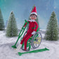 A Scout Elf® sitting in the wheelchair wearing the cast with crutches included in the Polar Props™ Elfcare Mobility Set, spinning around in this product video to give customers a 360 degree view of the product