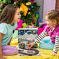 A pair of girls playing with the Spin & Soar 12-Day Countdown to Christmas advent calendar set in front of a Christmas tree